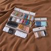 A collection of 8 solid color brooch pins in various shades and finishes packaged in small clear plastic holders.
