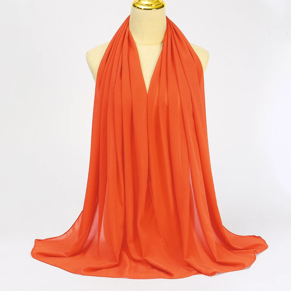 Oranger Chiffon-Hijab-Schal über dem Hals und den Schultern eines Mannequins drapiert.