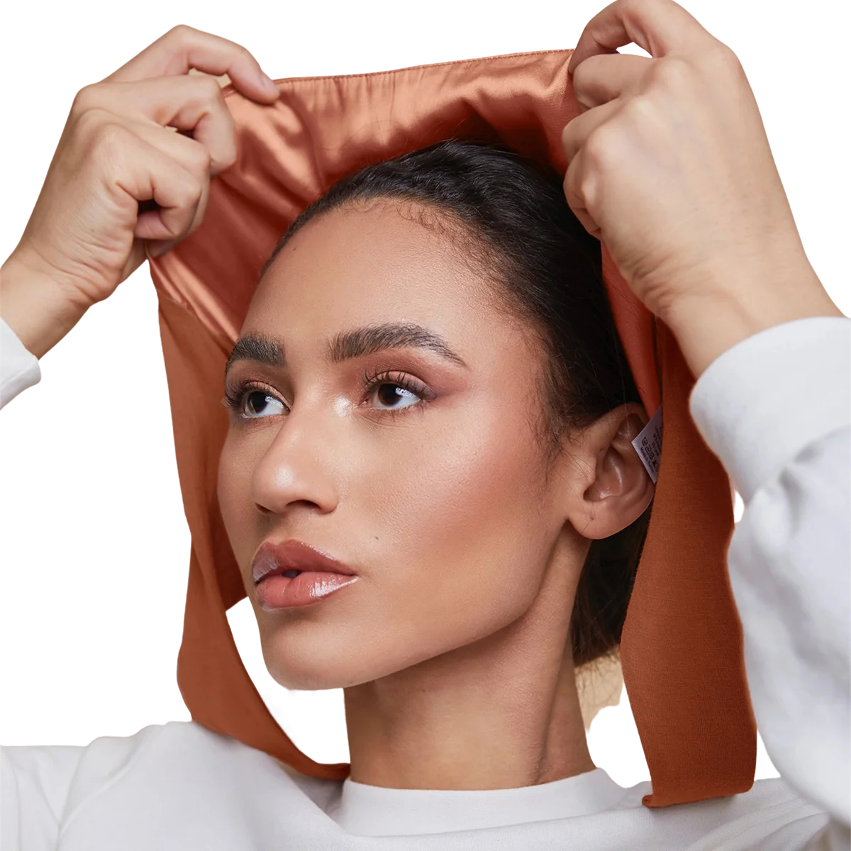 Une femme ajuste un foulard instant couvrant à double couche en satin sur sa tête.