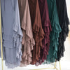 A display of ruffled two-layer chiffon hijabs in various muted tones including gray, brown, burgundy, and green.