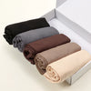 Ein Set aus fünf einfarbigen Jersey-Hijab-Schals in Schwarz, Grau, Braun, Beige und Tan präsentiert in einer weißen Box.