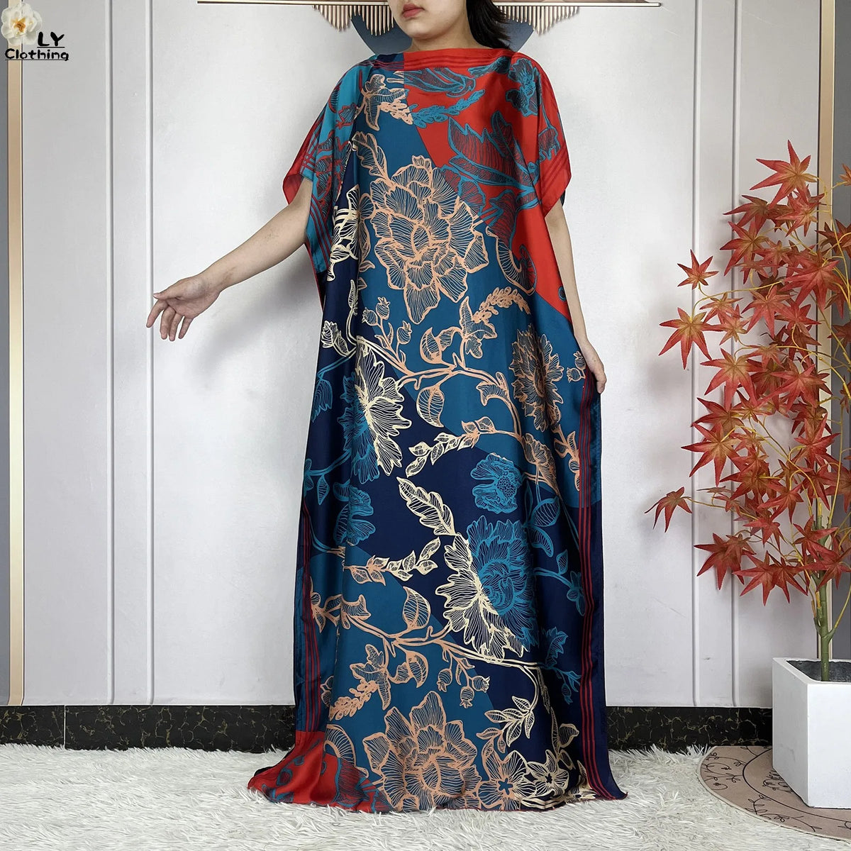 Eine Frau modelliert ein blau-orangees florales Sommer-Seidenabaya-Kaftankleid.