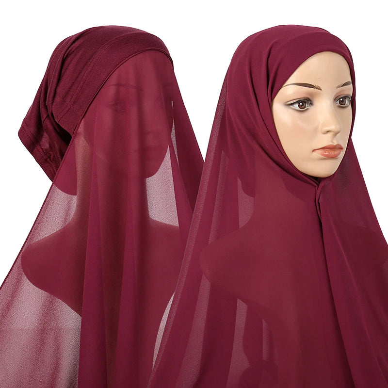 A woman wearing a deep maroon chiffon instant hijab with a modal cotton cap.