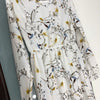 Weißes Maxi-Kleid mit Boho-Blumenmuster in Dunkelbraun, Gelb und Blau.