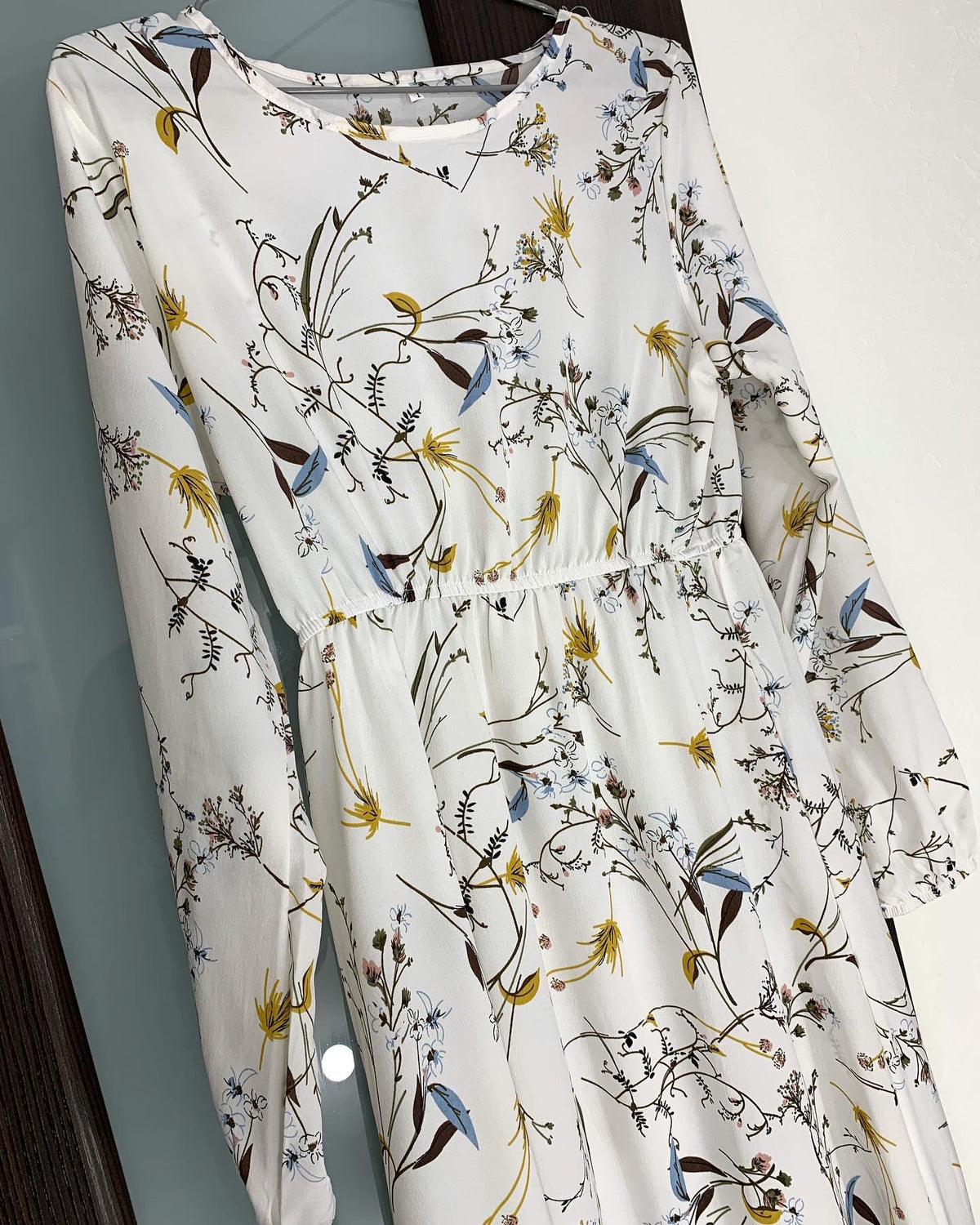 Weißes Maxi-Kleid mit Boho-Blumenmuster in Dunkelbraun, Gelb und Blau.