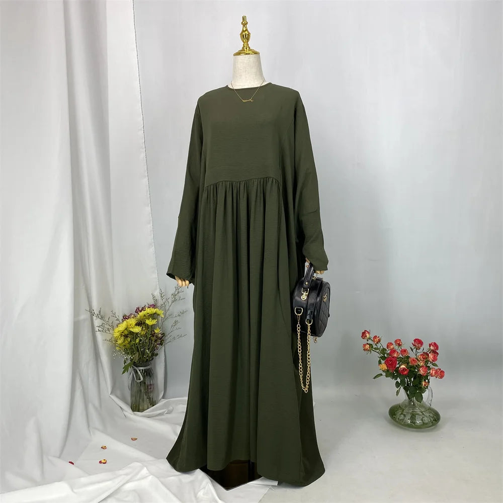 Elegante olivgrüne Batwing-Abaya auf einem Mannequin vor weißem Hintergrund.