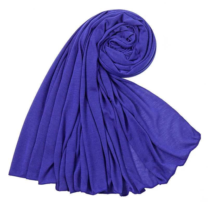 Ein tiefviolettes, einfaches Baumwoll-Jersey-Halstuch elegant gewickelt und drapiert.