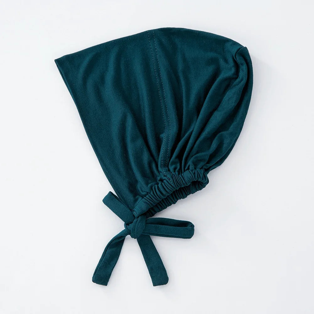 Dunkeltealiges Samt-Tuch, zusammengefaltet und gebunden, als inneres Hijab-Bonnet