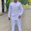 Un homme portant un costume de mariage musulman traditionnel africain blanc, composé d'une tunique à manches longues et d'un 