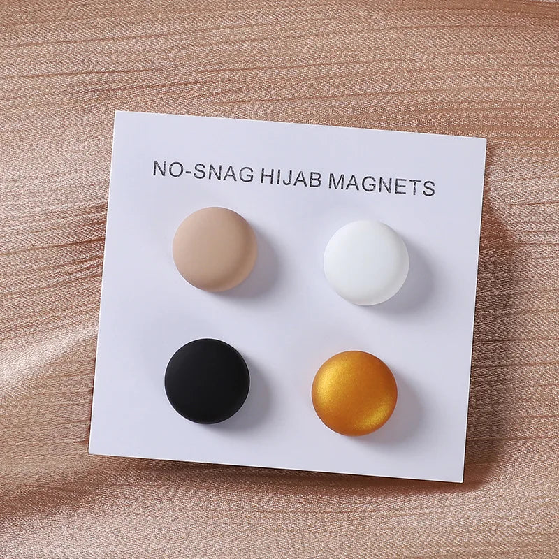 A white card displays four round magnets in various colors including beige, white, black, and gold.