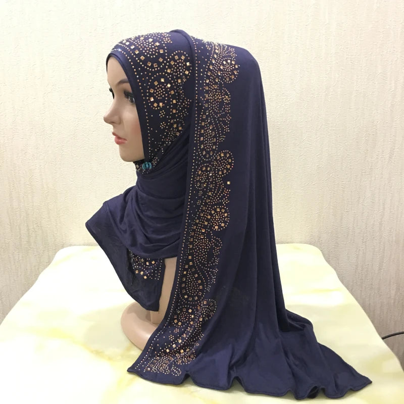 Écharpe de maillot bleu foncé avec des ornements en cristal doré drapée sur un mannequin.