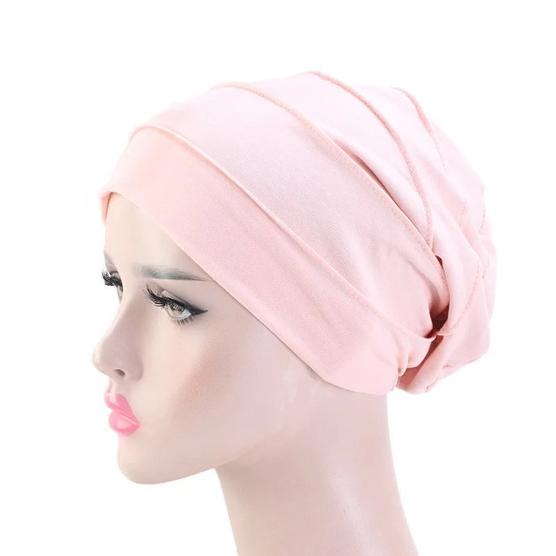 Hellrosa Stretch-Baumwoll-Beanie-Turban-Hut auf einem Mannequin-Kopf.