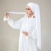 Eine Frau trägt einen weißen Instant-Hijab aus elastischem Modal-Jersey mit Trägern und hält einen weißen Stoffstreifen.
