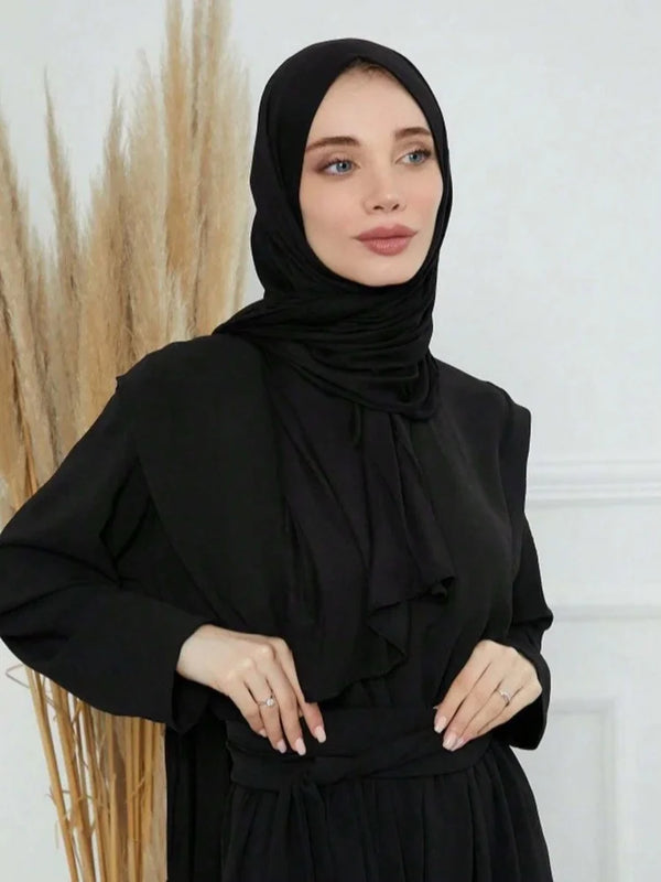 A woman wearing a black modal cotton jersey hijab scarf and black clothing.