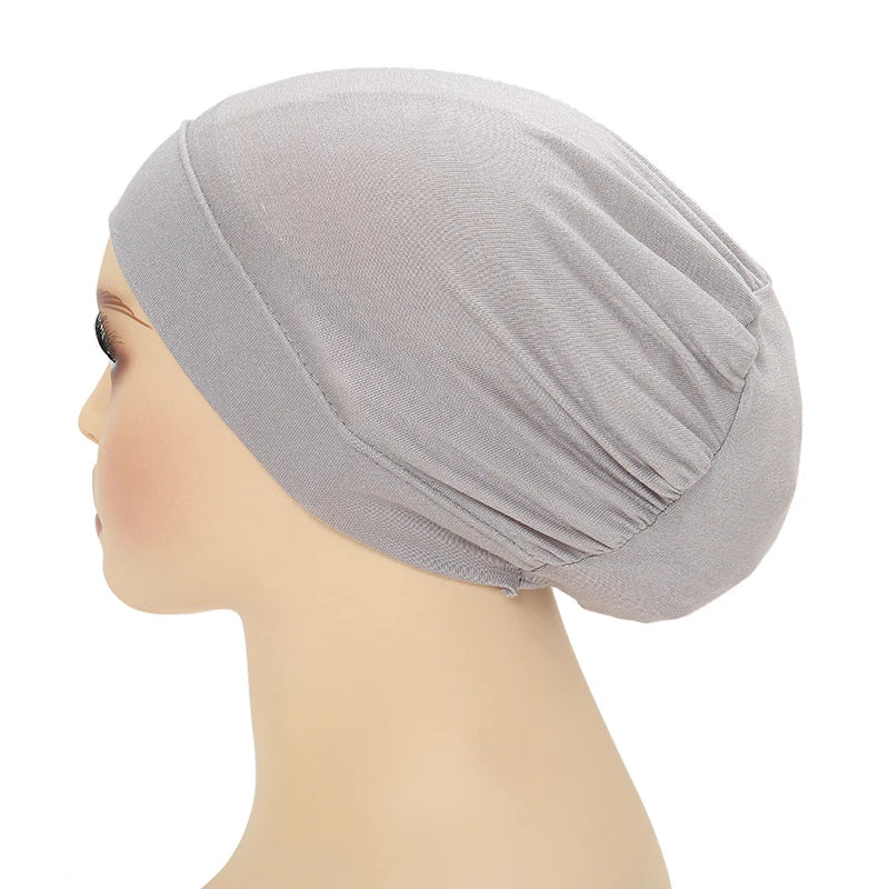 Un turbante instantáneo color gris claro mostrado en un maniquí de cabeza.
