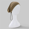 Beiger Luxuskleid-Turban aus Baumwolljersey auf weißem Mannequin.