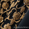 Close-up of gold floral beaded embroidery on a black fabric, likely part of an abaya set.
