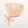 A light peach colored adjustable cotton jersey inner hijab cap tied with a bow.