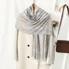 Abrigo beige con un chal bordado tipo paisley azul claro y beige sobre el cuello.