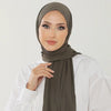 Una mujer vistiendo un pañuelo hijab de algodón premium elástico verde oliva con una blusa blanca.