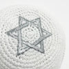Kippah blanche tricotée à la main avec un motif d'étoile à six branches argentée.