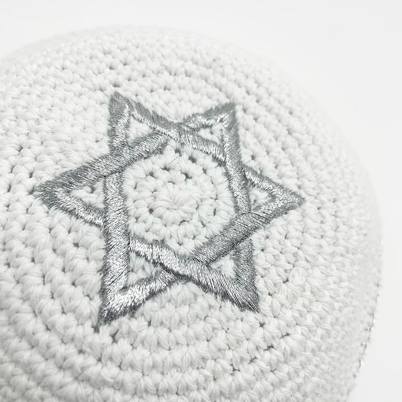 Kippah blanche tricotée à la main avec un motif d'étoile à six branches argentée.