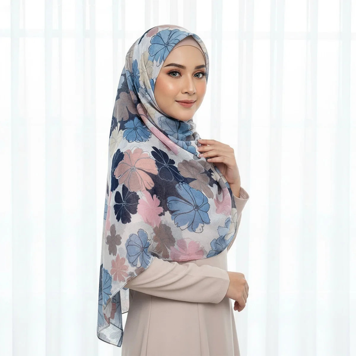 Eine Frau trägt einen eleganten Blumen-Viskose-Hijabschal in sanften Pink- und Blautönen.