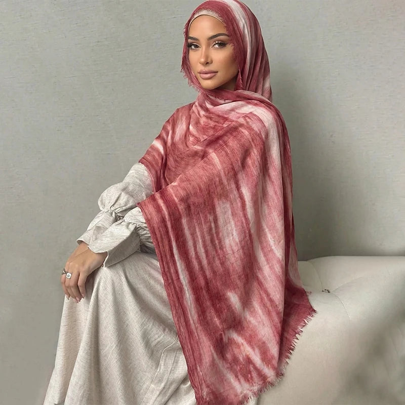 Una mujer usando un pañuelo hiyab floral de acuarela rosa y blanco sobre su hombro.