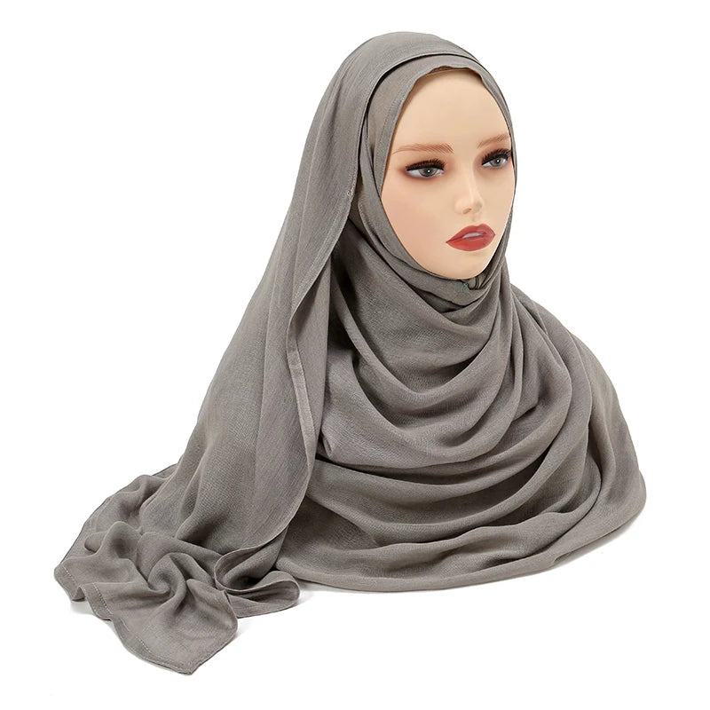 Pañuelo de algodón rayón gris plano drapeado sobre la cabeza de un maniquí.