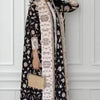 Una mujer modela un cárdigan abrigo abaya plisado negro y blanco con detalles dorados.