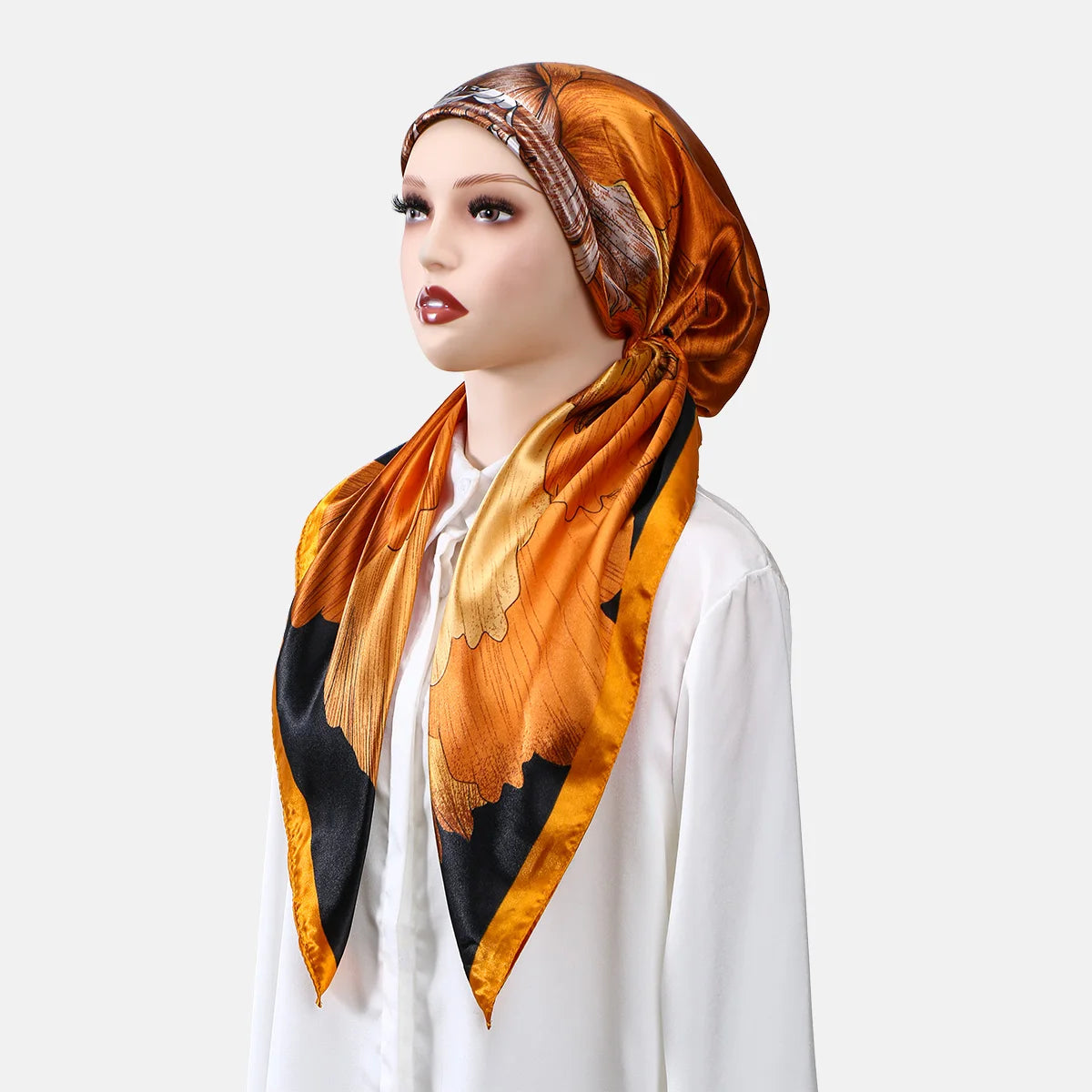 Eine Frau modelliert einen orange-schwarz gedruckten Satin-Seid-Hijabschal um ihren Hals.