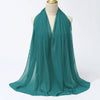 Ein türkis-farbiger Chiffon-Hijabschal, der um den Hals einer Mannequin drapiert ist.