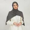 A woman wearing a gray stretchy jersey plain hijab scarf and a white jacket.
