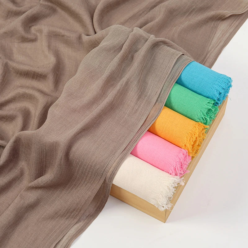 Pila de pañuelos de hijab de modal de bambú elegantes doblados en varios colores pastel como verde azulado, menta, naranja y 