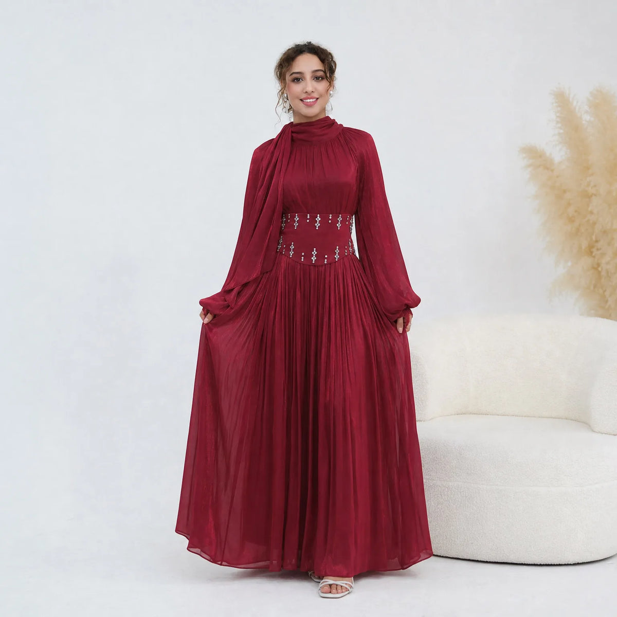 Un mannequin portant une longue abaya marron avec ceinture ornée.