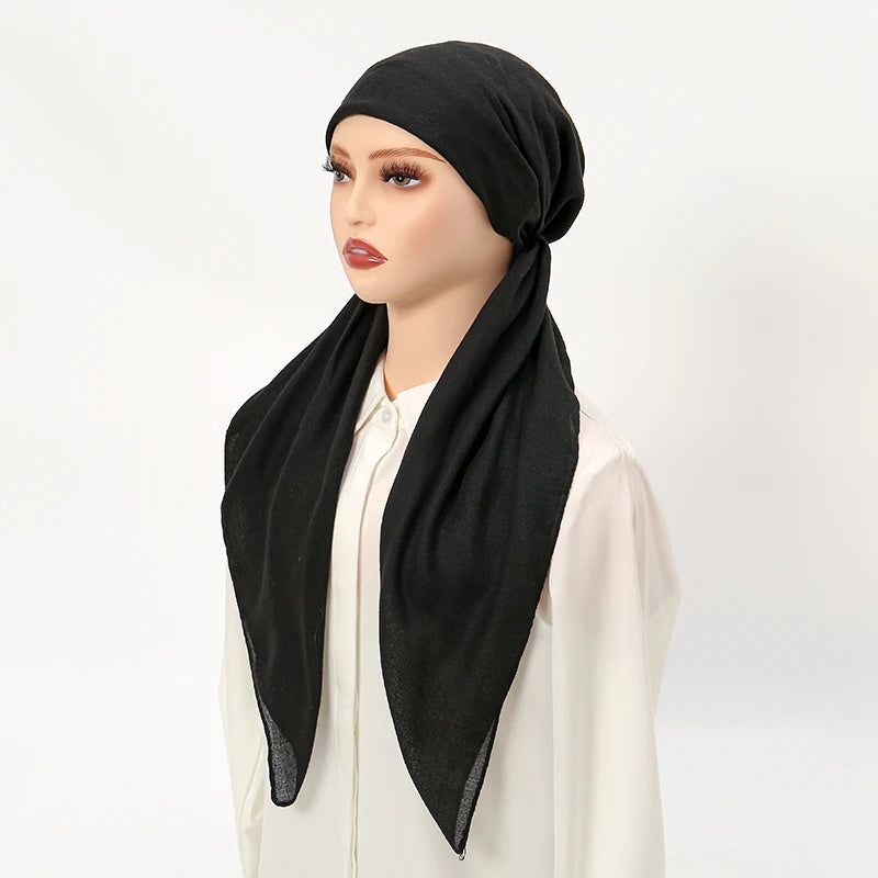 A model wearing a black solid linen elastic headscarf cap and white top.