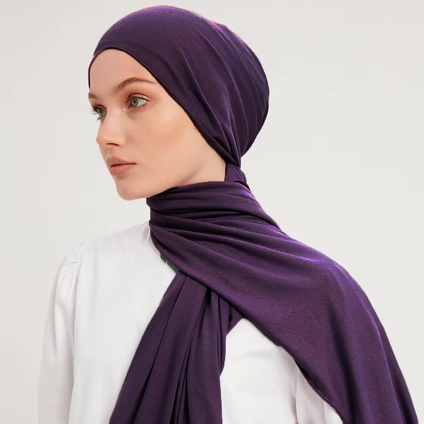 A woman wearing a deep purple stretchy premium cotton hijab scarf