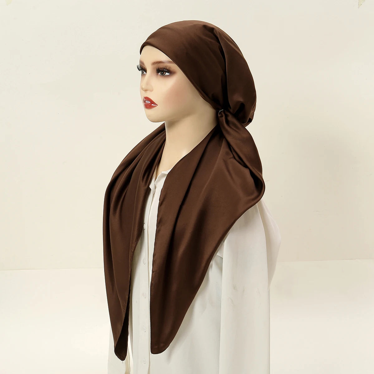 A model wearing a draped brown satin silk instant hijab scarf over a white top.