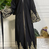 Abaya kaftan de lujo negro con bordado dorado mostrada en maniquí.