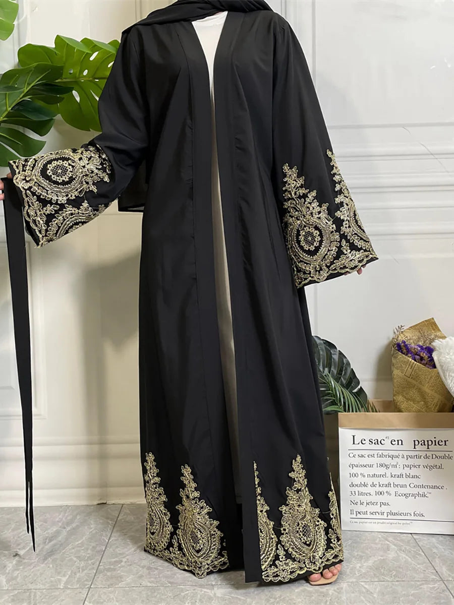 Abaya kaftan de lujo negro con bordado dorado mostrada en maniquí.