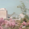 Weichgestellte Außenaufnahme mit rosa Blüten und einem hellen Gebäude unter einem blassen Himmel.