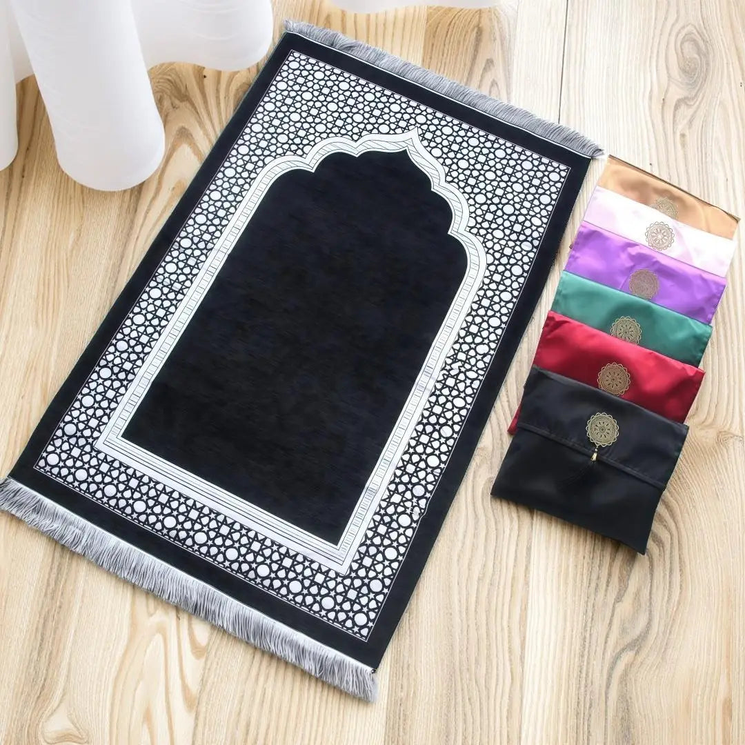 Un juego de tres alfombras de oración musulmanas de patrón blanco y negro con bordes fruncidos, expuestas sobre una superfici