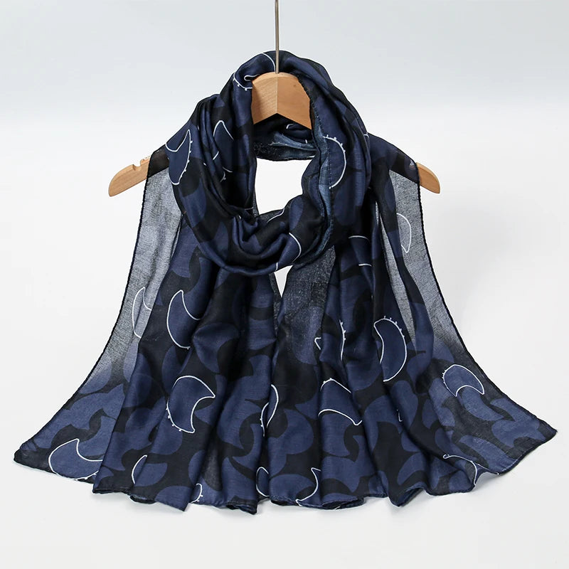 Pañuelo transparente azul oscuro con estampado de luna creciente acuarela blanca, colgado en una percha de madera