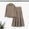 Beige, eleganter, schlichter Blusen- und Mehrteil-Kleidungs-Set auf einem Bügel.