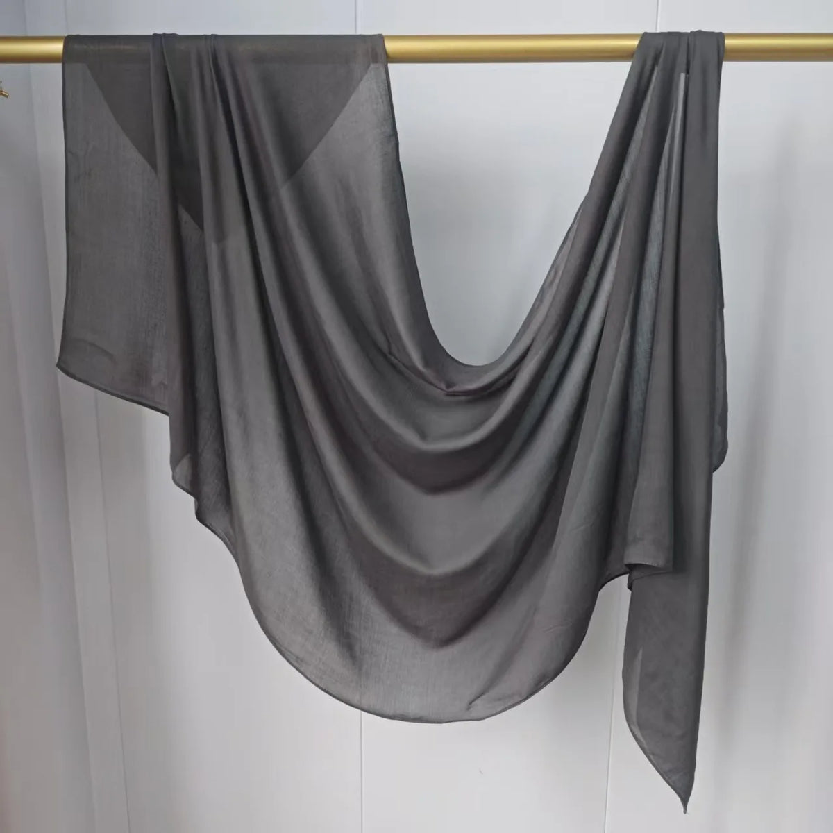 Foulard hijab uni gris foncé drapé sur un cintre or