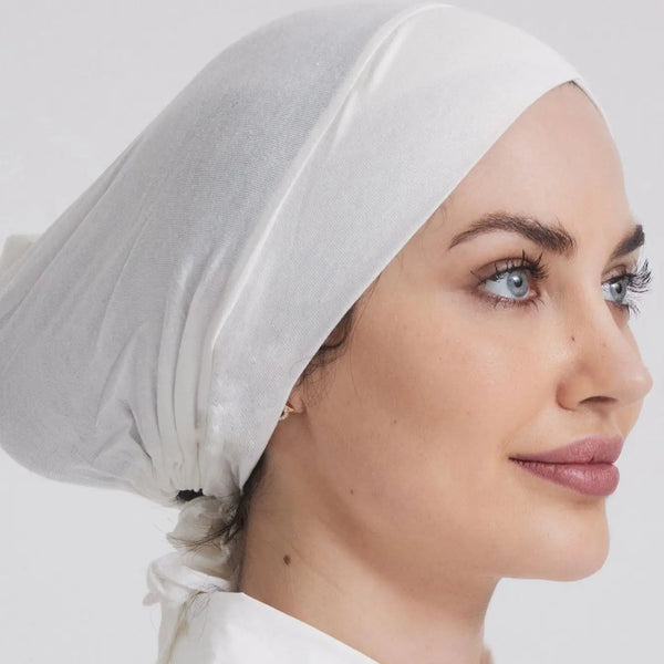 Close-up of a woman wearing a white adjustable cotton jersey inner hijab cap.