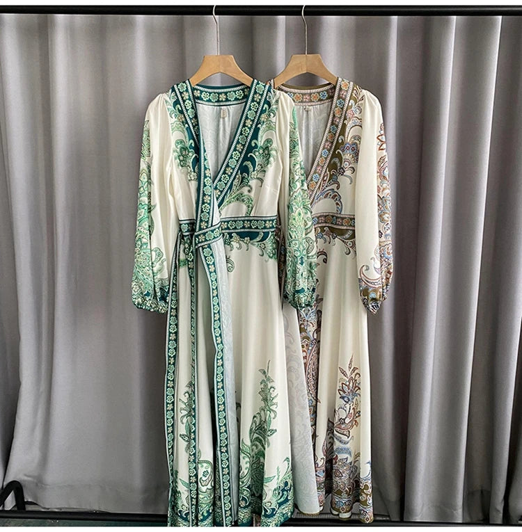 Langes weißes Maxi-Kleid mit türkisen und braunen Blumenstickereien an einem Holzstab hängt.