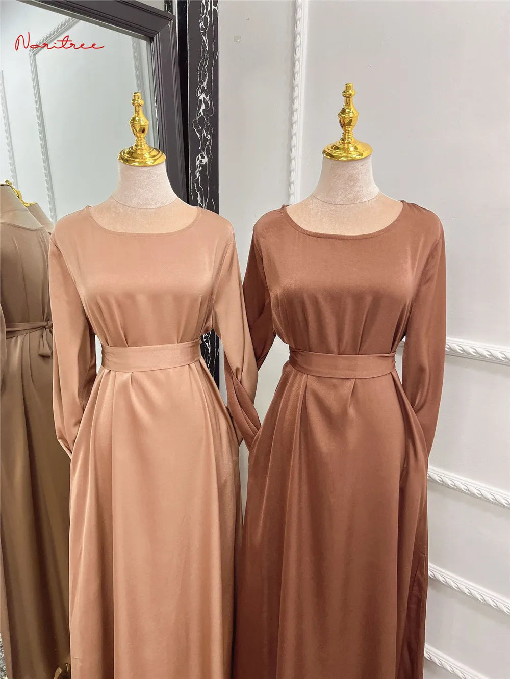 Lange, fließende Abaya in pudriger Rosatfarbe auf einem Mannequin.