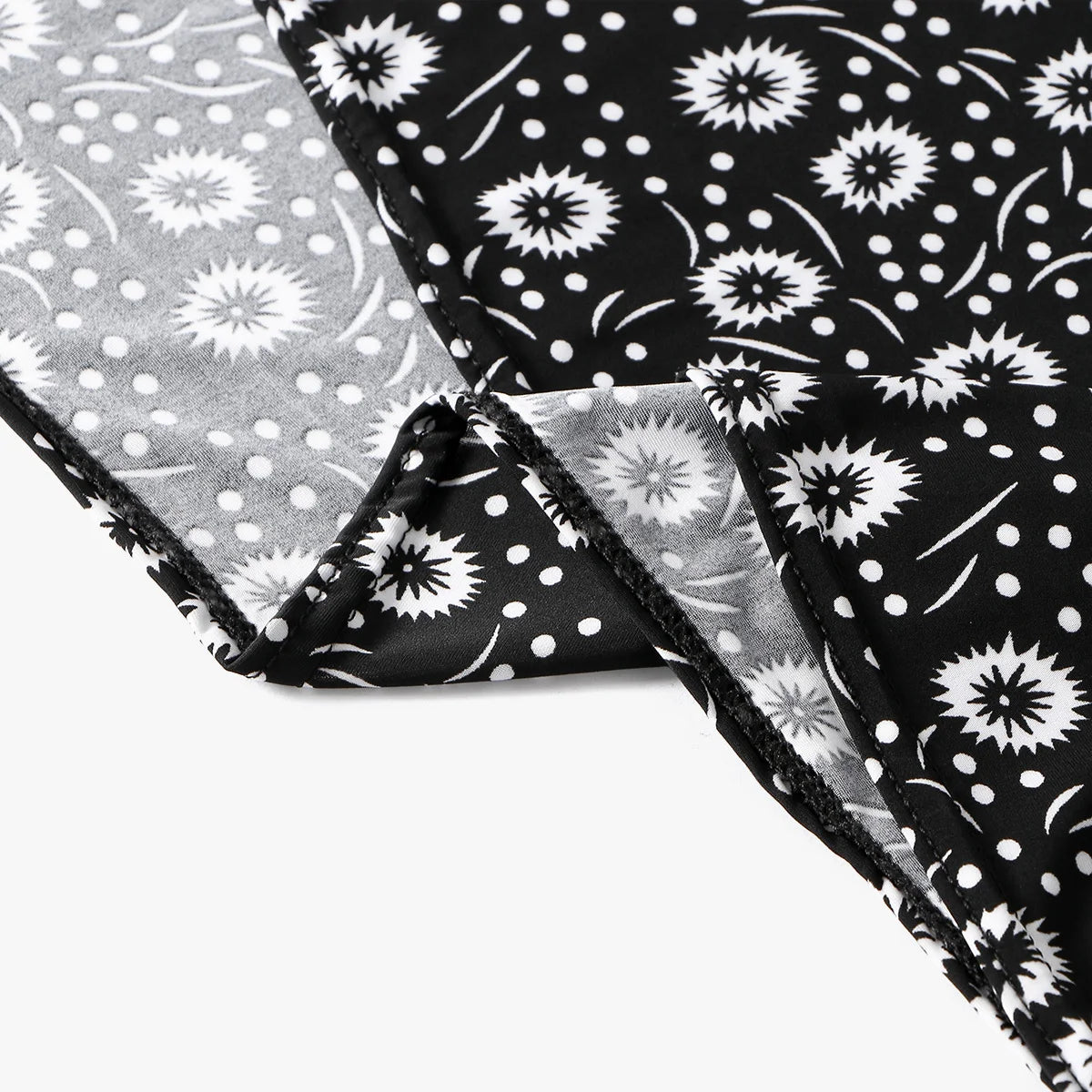 Primer plano de tela de lino floral blanco y negro con lunares y patrones de estrellas.