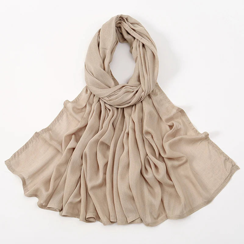 Pañuelo/chal de algodón rayón beige, drapeado alrededor del cuello y los hombros.